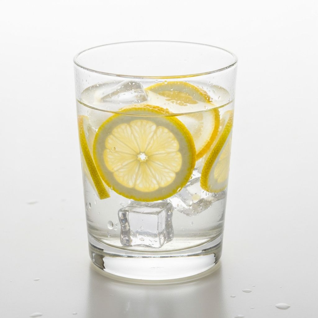 Glas Wasser mit Zitronenscheiben und Eis